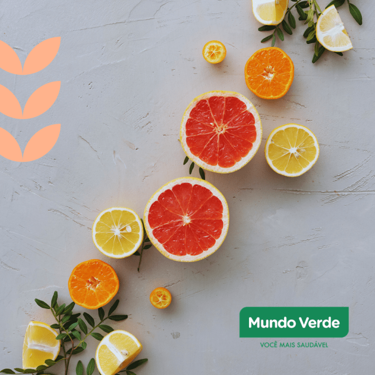 Imagem com fatias de frutas cítricas como grapefruit, limão e laranja, dispostas sobre uma superfície clara com folhagens, representando alimentos ricos em antioxidantes naturais, vitamina C e compostos anti-inflamatórios. Logo da marca Mundo Verde no canto inferior direito.
